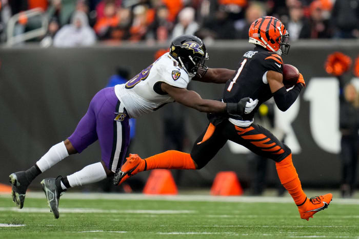 wide receiver Ja'Marr Chase runs with the ball as Baltimore Ravens linebacker Roquan Smith reaches out to try to tackle him